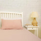 Arranged on a bed, the Pink Solid Bedsheet, a pale pink king and queen size cotton bedsheet you can buy online at Sukham Home, a sustainable furniture, gardening and home decor store in Kolkata, India