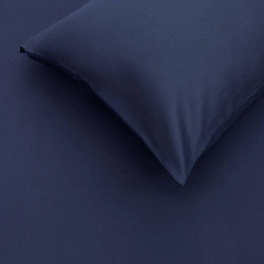The pillow case and sheet of the Navy Blue Classic Solid Bedsheet, a king size and queen size cotton bedsheet you can buy online at Sukham Home, a sustainable furniture, gardening and home decor store in Kolkata, India